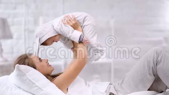 可爱的小妈妈抱着小可爱的小宝宝在玩情绪激动视频的预览图