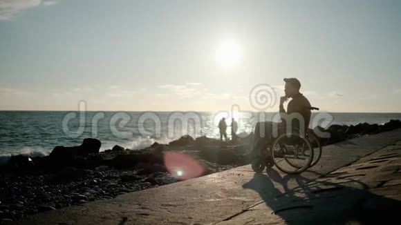 孤独的成年残疾人坐在海边沉思着海景视频的预览图