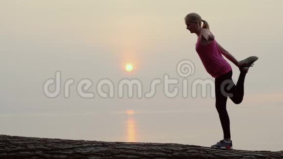 活跃的中年妇女在海边风景如画的地方做伸展运动和平衡运动视频的预览图