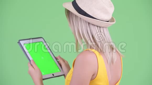 使用数码平板电脑的年轻金发美女的近距离后视镜视频的预览图