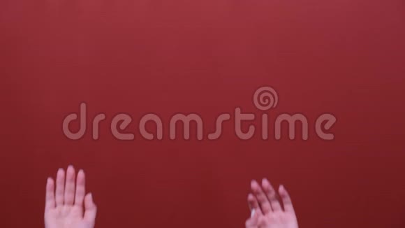 女人的手在红色背景的镜头前挥舞视频的预览图