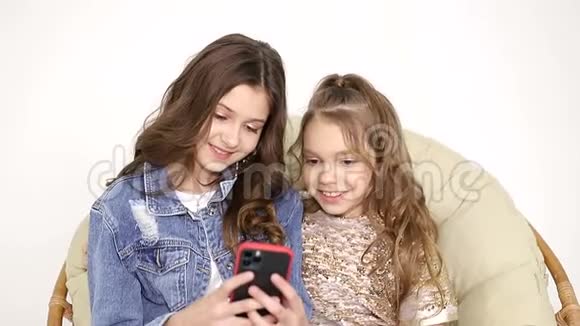 两个姐妹在家自拍微笑的朋友用电话自拍视频的预览图