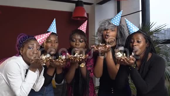漂亮的五个非洲女孩在生日聚会上吹着金色的纸屑视频的预览图
