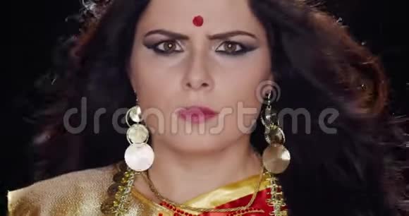 年轻的印度女人棕色的眼睛和金色的耳环摆着4k的姿势视频的预览图