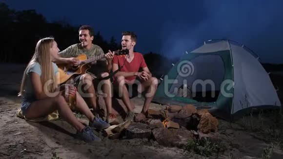 喝酒的朋友在露营时弹吉他视频的预览图