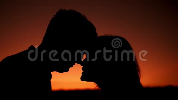 情侣们在夕阳的橙色背景下迎面走来视频的预览图