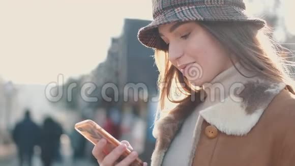 一个戴着帽子的漂亮黑发女人正在城市街道上喝一杯外卖咖啡视频的预览图