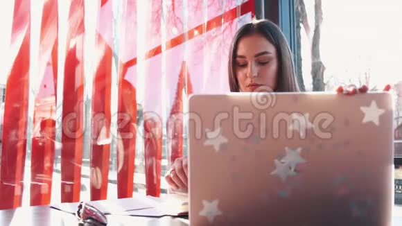 一个深色头发的欧洲女孩正在用笔记本电脑工作视频的预览图