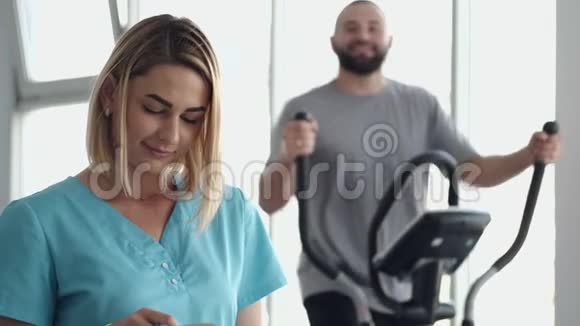 在健身房做运动的病人和治疗师视频的预览图