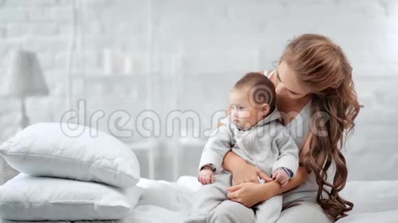 美丽的年轻妈妈抱着小宝宝享受母爱视频的预览图