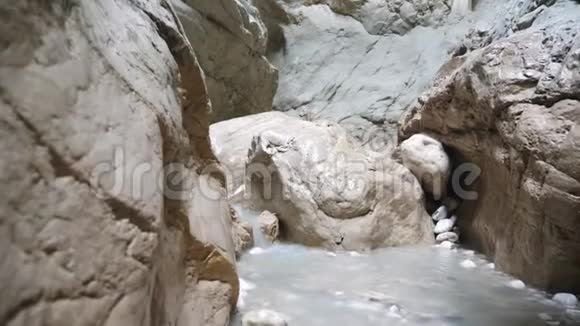 无法辨认的年轻人背着背包走过狭窄的峡谷男性徒步旅行者探索岩石峡谷克服视频的预览图