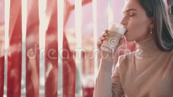 那个美丽的黑发欧洲女孩正在咖啡馆里喝拿铁视频的预览图