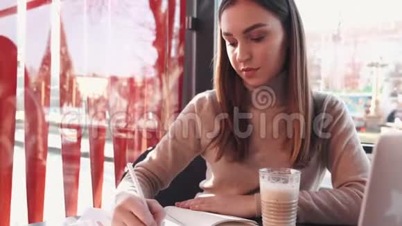 那个漂亮的黑发女人正在咖啡馆里处理文件视频的预览图