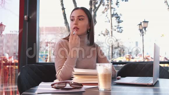 这位美丽的黑发欧洲女孩正在涂上唇彩视频的预览图