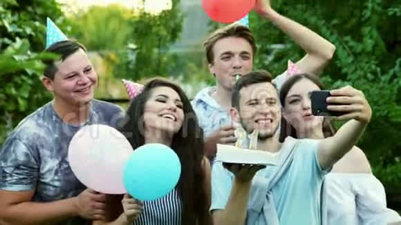 快乐男人在庆祝生日的时候在手机上自拍朋友祝贺在手机上拍照视频的预览图