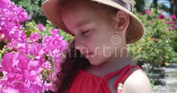 戴草帽的小女孩的肖像她正在考虑美丽的花蕾概念婴儿儿童儿童视频的预览图