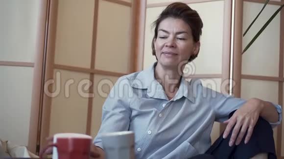 一位优雅衣着考究成熟的女士在房间里打开一个奶油罐的肖像带有现代设计那个女人要视频的预览图