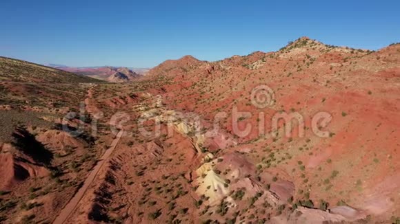 地面乡村公路穿过沙漠有红色的沙丘和岩体视频的预览图