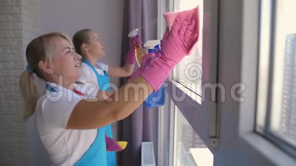 积极的女性清洁工在室内洗窗户视频的预览图