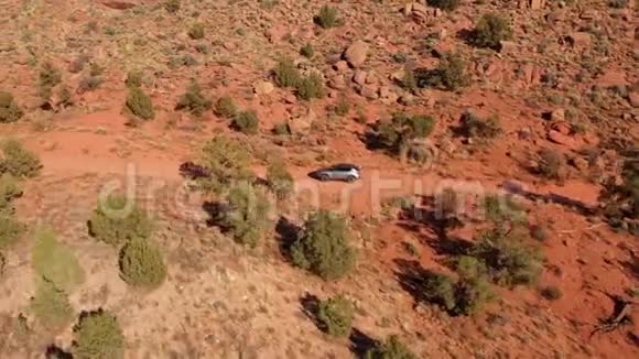 在阳光明媚的日子里苏夫在尘土飞扬的乡村公路上穿过一片红沙沙漠视频的预览图