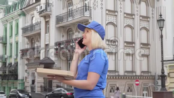 女快递员打电话给在城里送披萨的客户视频的预览图