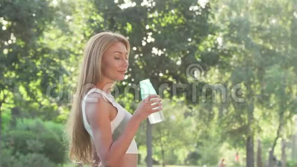 喝完水后可爱开朗的女人对着镜头微笑视频的预览图
