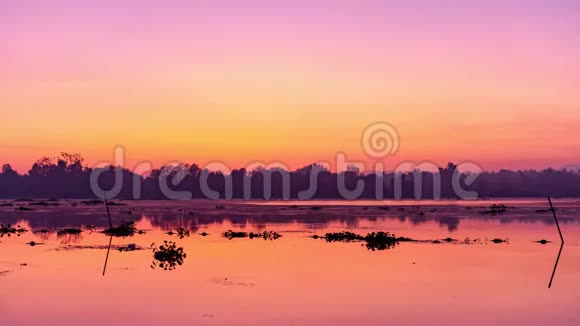湖面上美丽的日出或日落天空与水中反射光的景观时间点视频的预览图