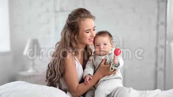 年轻美丽的母亲拥抱和亲吻她的小宝宝有积极的情感感受爱视频的预览图