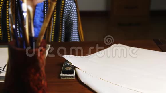 女孩在木桌上写中国书法视频的预览图