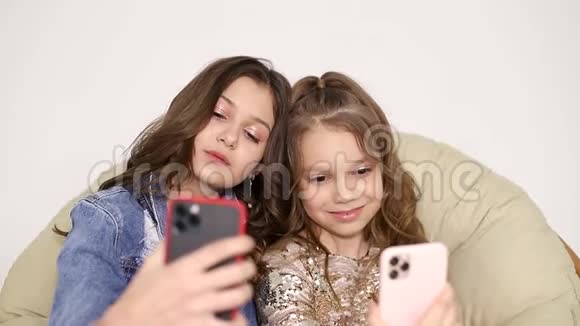 两个姐妹在家自拍微笑的朋友用电话自拍视频的预览图