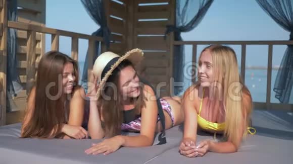暑假戴帽子的漂亮女孩和朋友们在海滨的平房里玩得很开心聊天摆姿势拍照视频的预览图
