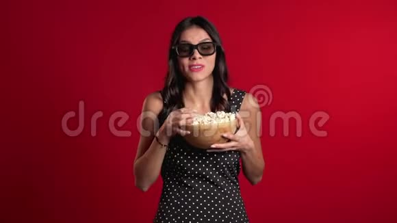 年轻的西班牙裔女性戴着3d眼镜看喜剧电影吃着红色爆米花视频的预览图