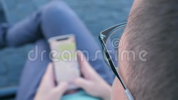 一个坐在长凳上用智能手机写信息的人视频的预览图