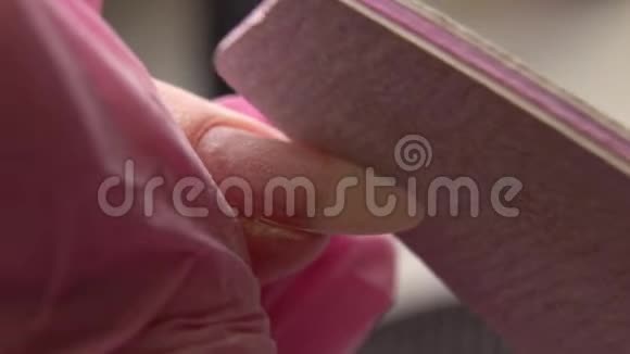 美甲专家抛光指甲给客户指甲美容师在美甲沙龙给女人整理指甲女人正在视频的预览图