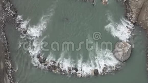 从河中的石坝上流过的冰川水视频的预览图