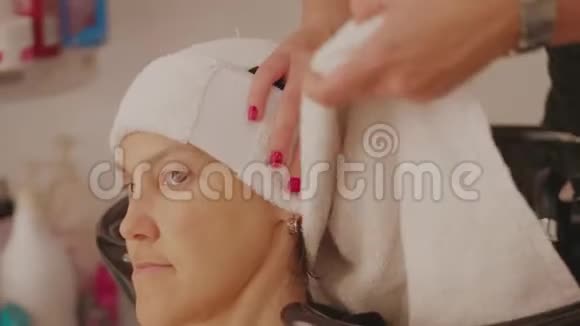理发师用毛巾包着女人洗头发视频的预览图