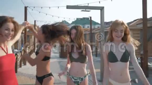 暑假快乐的女孩穿着泳衣美丽苗条的身体在海岸上玩得开心快乐地奔跑和欢笑视频的预览图
