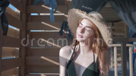 戴着帽子的女孩穿着泳衣的漂亮年轻女子的肖像在镜头前微笑享受阳光视频的预览图