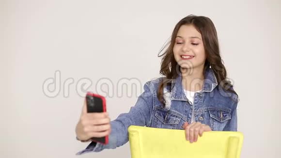 微笑的小女孩使用现代小玩意孤立的在黄色背景上视频的预览图