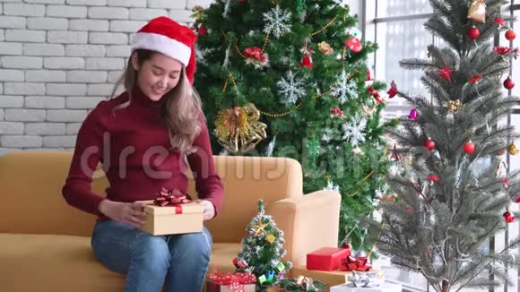 戴圣诞帽的年轻亚洲女孩圣诞假期圣诞礼物视频的预览图