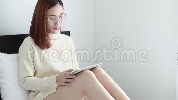 美女穿黄毛衣用电脑平板特写在家里购物生活方式视频的预览图