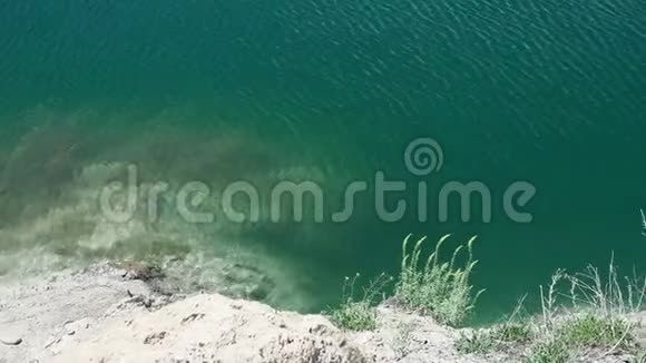 一个闪闪发光的蓝色绿色湖泊的顶部景色湖泊视频的预览图