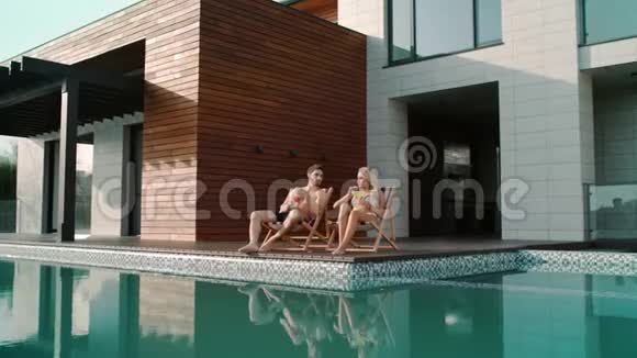 富有的夫妇在私人住宅的游泳池附近放松视频的预览图