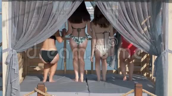 夏天的周末一群穿着泳衣的快乐女朋友在豪华的平房里休息举起他们长长的身体视频的预览图