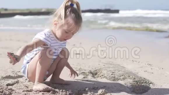 在海边沙滩上玩耍的有趣的小女孩视频的预览图