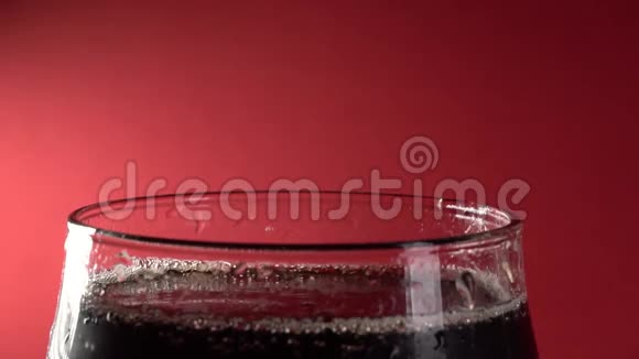 慢镜头特写镜头红色背景下的可乐倒入玻璃杯视频的预览图