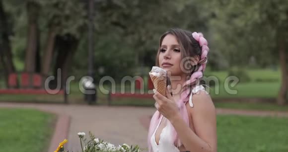 有辫子的漂亮女人在公园里吃冰淇淋视频的预览图