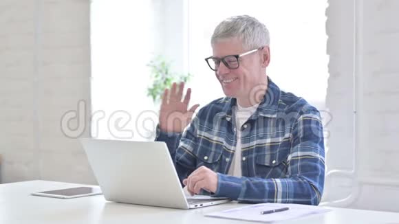 性格开朗休闲的中年男人在笔记本电脑上做视频聊天视频的预览图