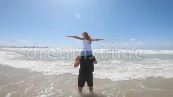 在一场海上风暴中快乐的父亲和女儿在海滩上玩耍友好家庭旅游生活方式的概念视频的预览图
