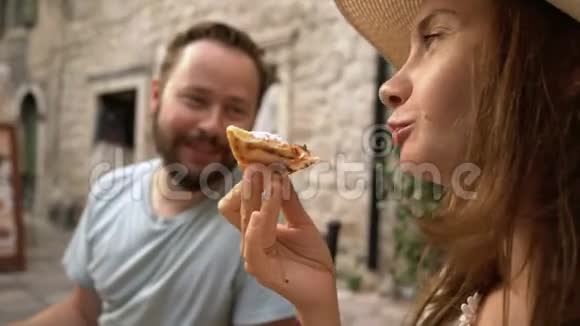一对年轻夫妇坐在咖啡馆里吃披萨聊天笑视频的预览图